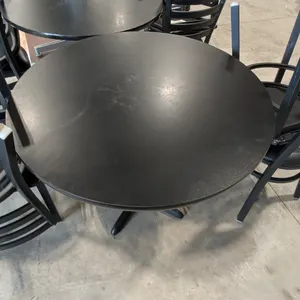 36" round dining table with (4) dining chairs. Table features a black round top mounted on a black pedestal base. Includes 4 matching black ladder-bac
