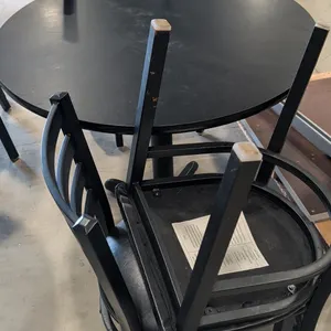 Dining table and chairs set. Includes (1) 36" round black dining table on a black metal pedestal base and (4) Belnick black metal ladder-back dining c