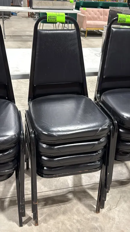 Stackable banquet chairs. Features black vinyl upholstered padded seats and backrests with black metal frames.