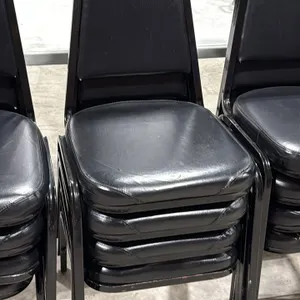 Stackable banquet chairs. Features black vinyl upholstered padded seats and backrests with black metal frames.