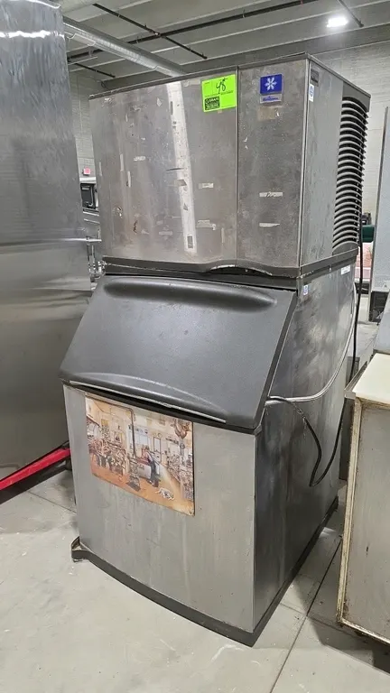 Manitowoc SY0504A modular ice machine with Manitowoc B570 ice storage bin. Features stainless steel exterior, air-cooled condenser, and front hinged b