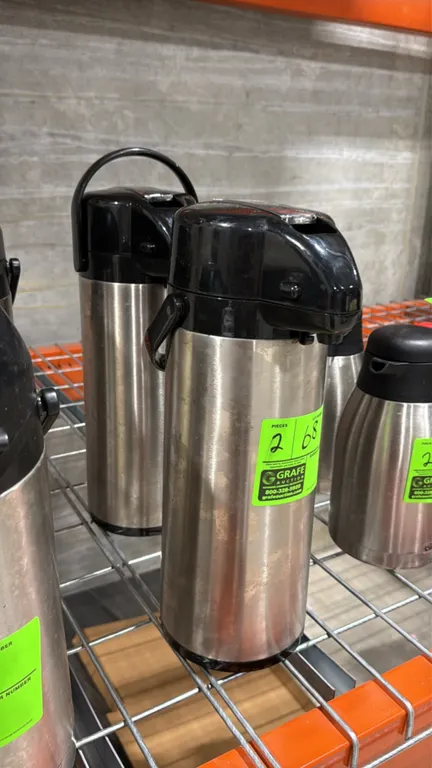 Stainless steel airpots. Features lever-action pump dispensing lids and integrated carrying handles with black composite trim.