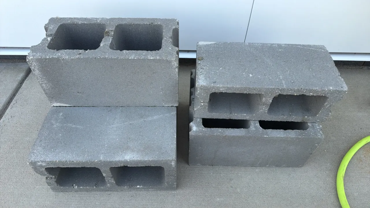 Assorted concrete cinder blocks. Features standard hollow-core concrete masonry construction.
