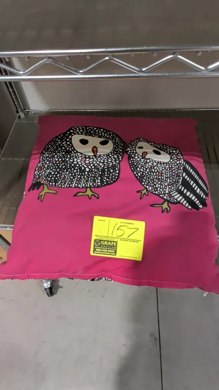 Decorative throw pillow. Features a pink front with stylized owl graphics and a black and white patterned reverse side. 20" x 20".