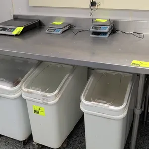 Stainless steel work table. Features a stainless steel top, integrated rear backsplash, and open base with tubular cross-bracing. 60"L. Mounted on tub