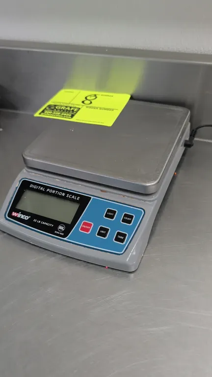 Winco SCAL-D22 digital portion scale. Features a 22 lb capacity, stainless steel weighing platform, digital LCD display, and push-button controls. NSF