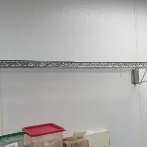 Stainless steel wire wall shelf. Includes (2) wall mounting brackets. 52"L. Wall-mounted design. Contents not included.