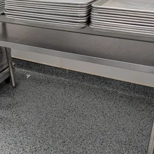Stainless steel work table. Features stainless steel top and undershelf. 60"L. Mounted on tubular metal legs with adjustable bullet feet. Sheet pans n