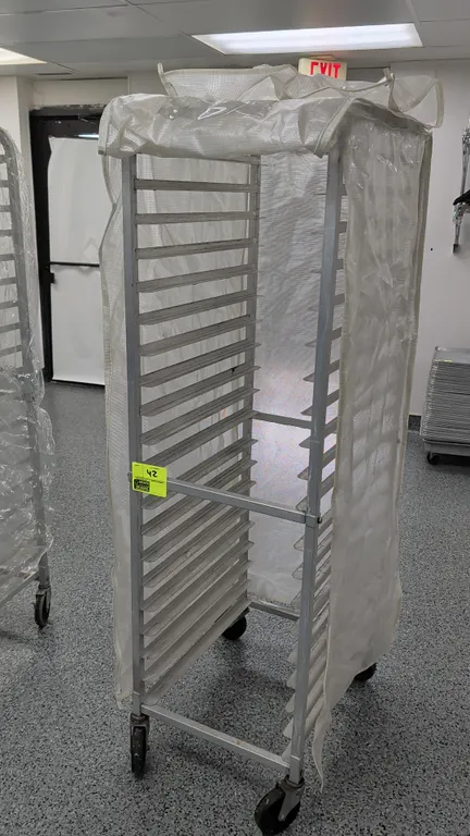 Front load channel sheet pan rack. 20-tray capacity designed for 18" x 26" pans. Features aluminum construction and includes a fitted protective cover