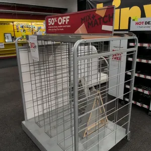 Metal portable merchandise rack. Features wire grid slot dividers, top signage header channel, side display panels, and solid base platform. 47".