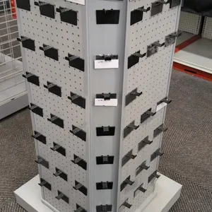 Laminate rotating merchandise display rack. Features multi-sided pegboard panels with plastic display hooks, corner card slots, and upper signage chan