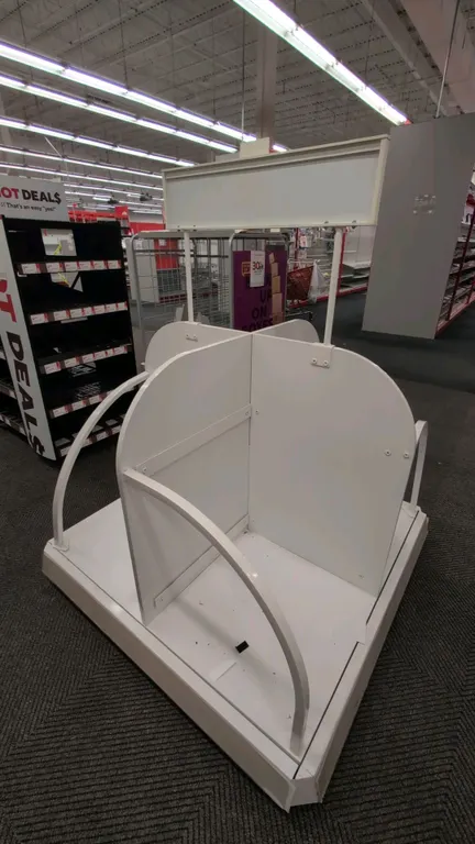 Metal and laminate 4-sided portable merchandise display rack. Features white laminate dividers, metal wire rails, and an overhead sign header. Dimensi