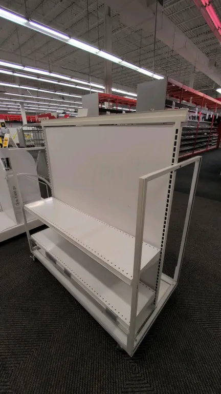 Metal portable double-sided merchandise display rack. Features white finish, solid center panel, adjustable metal shelves, and side end frames. 50"L.