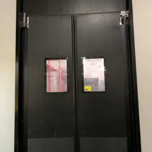 Polyethylene traffic swing doors. Features black poly panels, rectangular vision windows, lower kick plates, and mounting hinge hardware. 36"W x 105"H