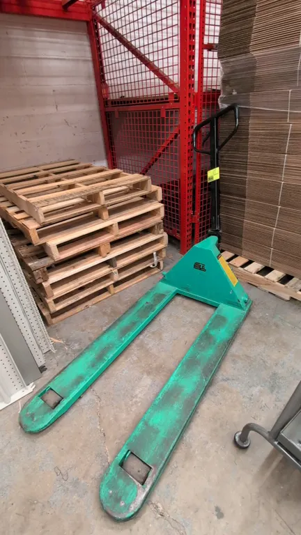 Wesco manual pallet jack. Features a 5,500 lb load capacity and 27"W x 48"L forks. Note: Handle is damaged at the base.
