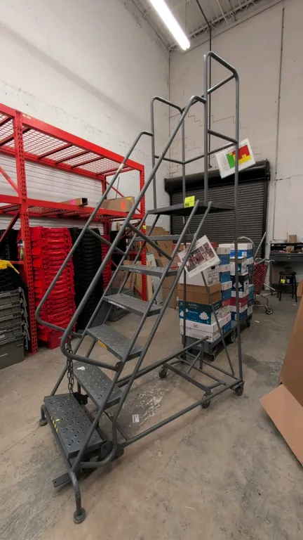 Tri-Arc steel warehouse stock ladder. Features perforated slip-resistant steps, top platform, and safety handrails. 450 lb weight capacity. 72" platfo