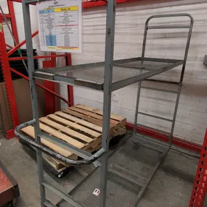 Metal 2-tier U-boat cart. Features expanded metal mesh deck and upper shelf, tubular steel end frames with push handle, and a 6-wheel caster configura