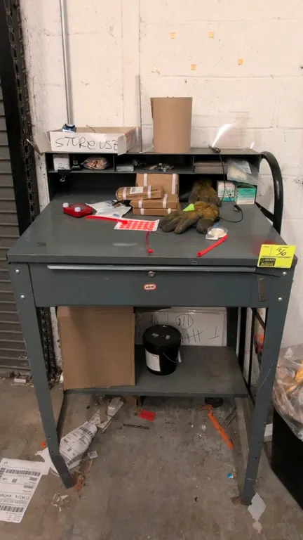 Edsal metal shop desk. Features upper organizer compartments, single pull-out drawer, and lower storage shelf. Dimensions: 34"W x 53"H. Gray painted s