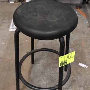 Foam cushioned stool. Features a round black molded foam cushioned seat and a black tubular metal 4-leg frame with an integrated circular footrest rin
