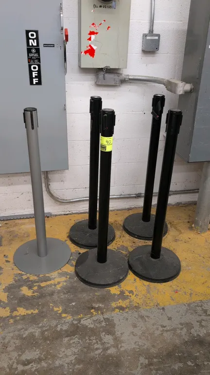 Assorted retractable belt crowd control stanchions. Features metal posts with weighted circular bases and multi-directional belt receivers. Includes b