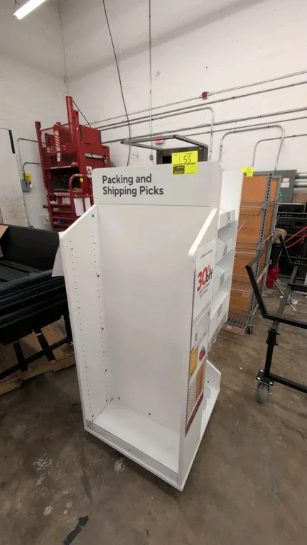 Laminate merchandise display rack. Double-sided construction featuring angled display shelves with front retaining lips, lower vertical storage slots,