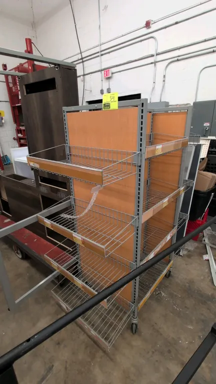 4-sided portable merchandise display rack. Features a gray metal frame with woodgrain laminate backing panels and adjustable wire basket shelves with