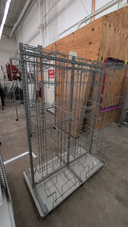 Metal portable merchandise display rack. Features double-sided wire display pockets with label holders. Dimensions: 51"W x 61"H. Mounted on a mobile b