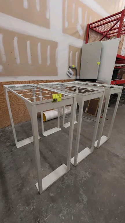 Metal merchandise display racks. Features white painted metal frame construction with wire grid top inserts and flat plate base feet. Dimensions: 47"