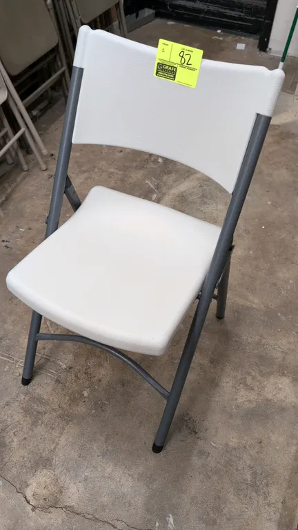 Poly folding chairs. Features white molded plastic seat and contoured backrest. Mounted on a gray metal folding frame.