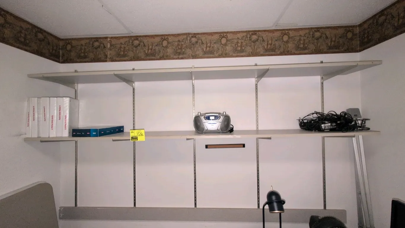 8'L 2-tier wall-mounted shelving unit. Features white laminate shelves with metal wall-mount standards and adjustable support brackets. Contents not i
