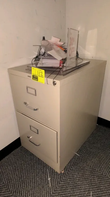 Staples 2-drawer metal vertical filing cabinet. Features label holders, metal pull handles, and top lock with key. 18". Putty finish. Contents not inc