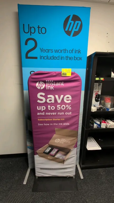 Metal sign display stands. Features modular tubular metal frames and flat weighted bases. Includes HP promotional fabric graphic slip covers.
