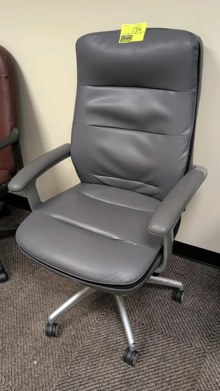 2018 Beautyrest 49404 high-back executive office chair. Features gray faux leather upholstery, cushioned seat and back, and padded armrests. Mounted o
