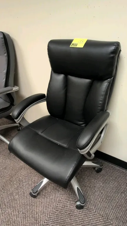 Sealy Posturepedic 9771G executive office chair. Features black faux leather upholstered seat and back, padded armrests, and pneumatic height adjustme