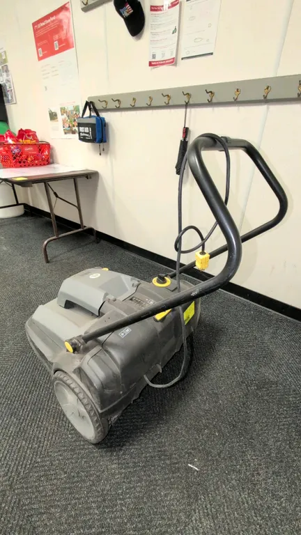 Windsor Radius 280X walk-behind floor sweeper. Features side broom attachment, adjustable brush height control, folding handle, and attached power cor