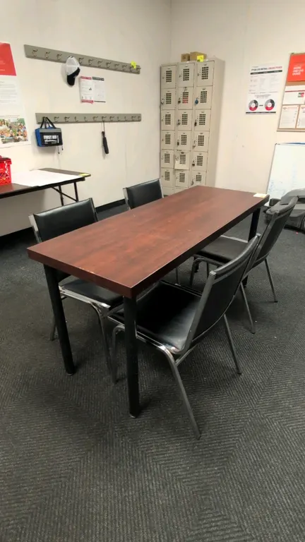 Laminate top table with chairs. Includes 64"L table featuring a wood-look laminate top and black metal legs, accompanied by (4) chairs with black faux