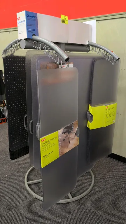 Metal merchandise display rack. Features curved hanging arms with display hooks and top signage holder. 36" x 67"H. Mounted on a circular metal base.