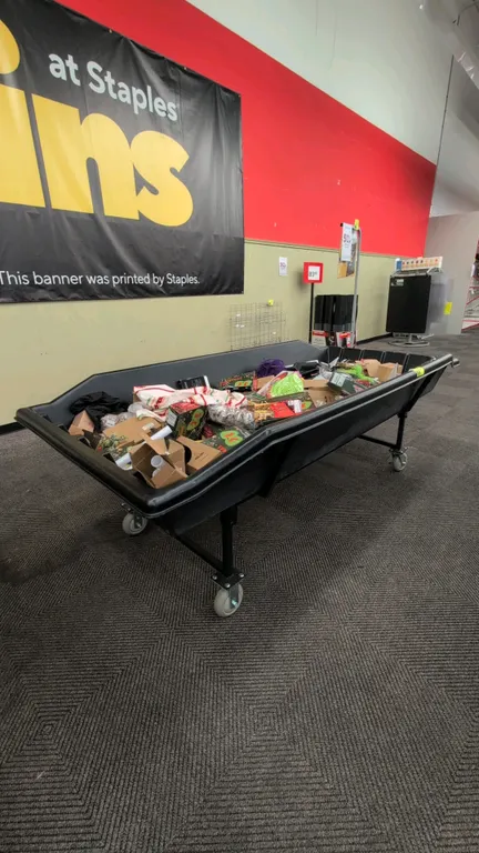 Poly portable dump merchandise rack. Features a molded black poly tub and black metal frame base. 105" x 50". Mounted on casters. Contents not include