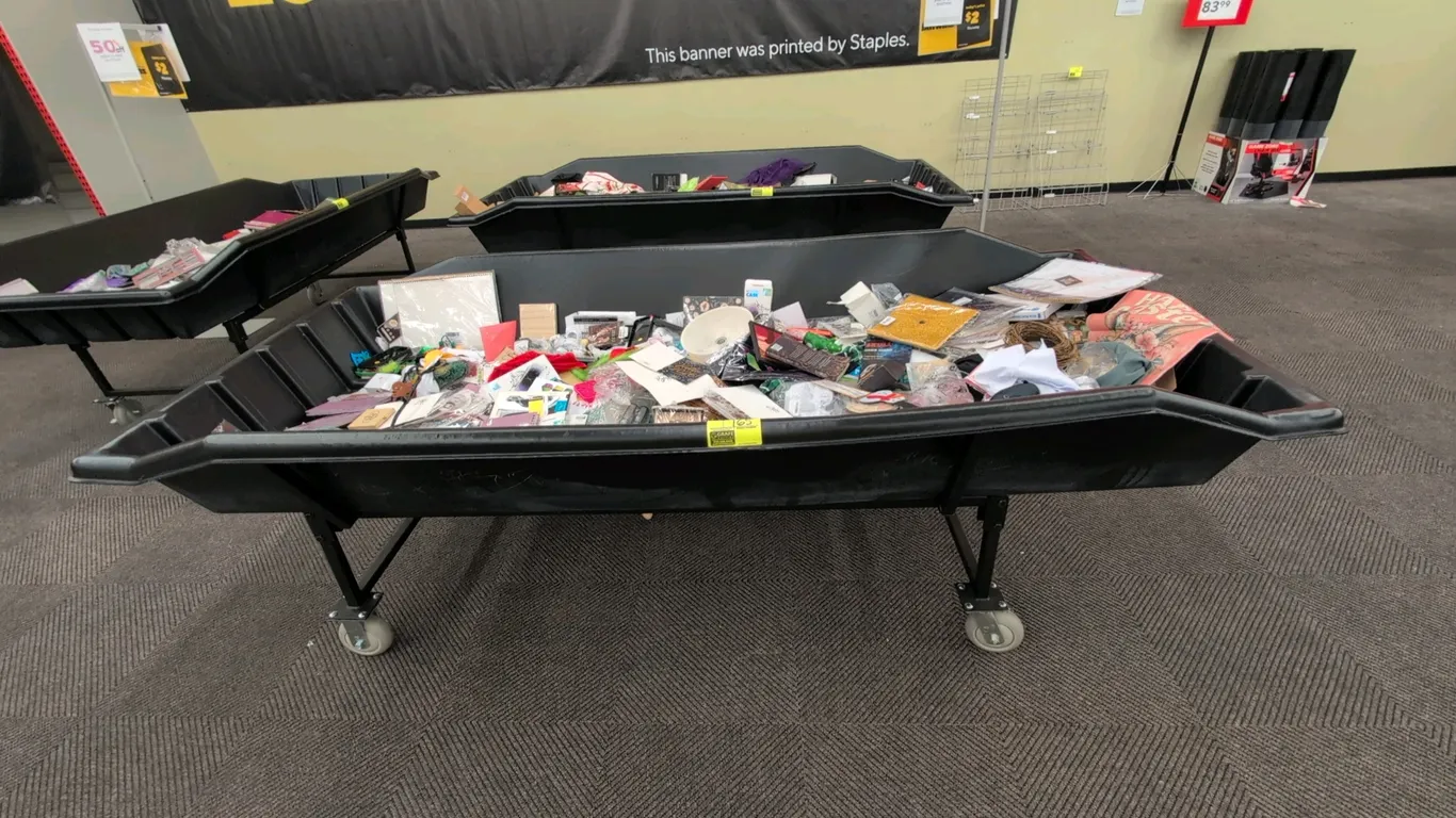 Poly portable dump merchandise rack. Features a molded black plastic tub. Mounted on a black metal base with swivel casters. Dimensions: 105" x 50". C