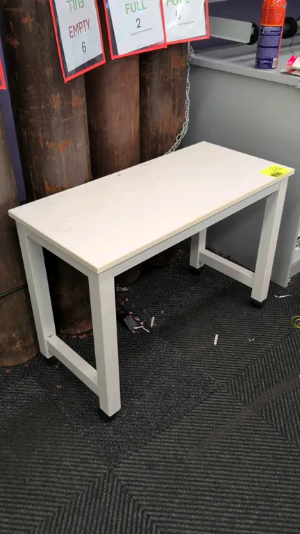 Laminate top portable table. Features a white laminate work surface on a painted metal frame. 3'L. Mounted on casters.