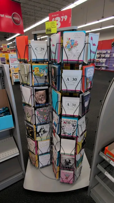 Rotating card merchandise display rack. Features multi-tier wire display pockets, rotating carousel design, and laminate top and base panels. 62"H. Mo