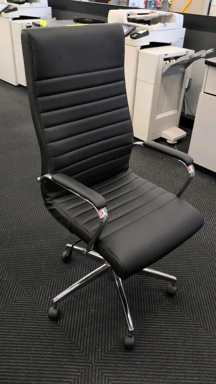 2024 Bentura 53234 high-back office chair. Features black ribbed faux leather upholstery and padded chrome armrests. Mounted on a 5-star chrome base w