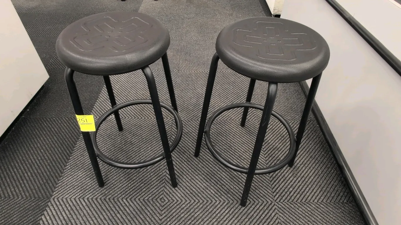 Foam cushioned stools. Features embossed black foam round seats and circular footrests. 27"H. Mounted on black tubular metal 4-leg bases.