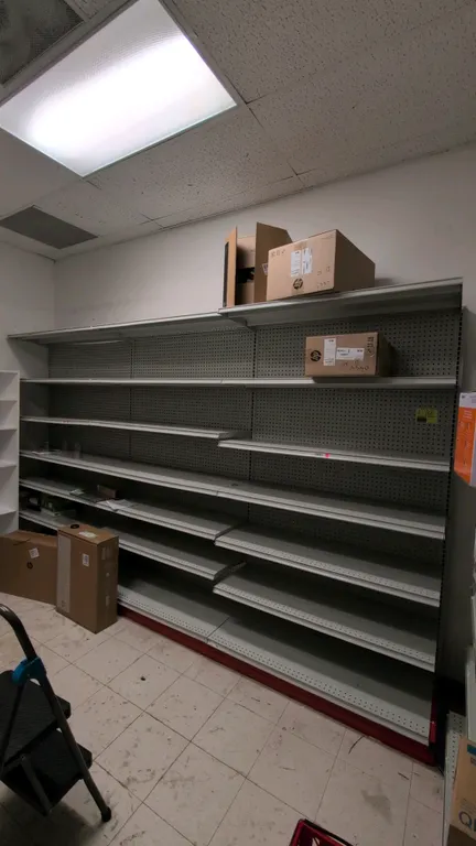 12'L of Madix wall shelving. 84"H uprights with 18"D base shelves. Features pegboard backing, adjustable upper metal shelves, and top canopy. Contents