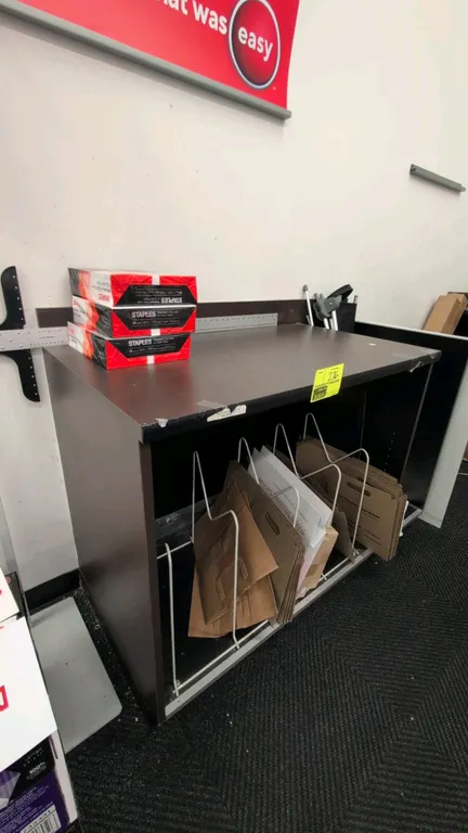 Laminate countertop work table with under-counter storage. Features dark brown laminate finish, rear backsplash lip, and open lower storage compartmen