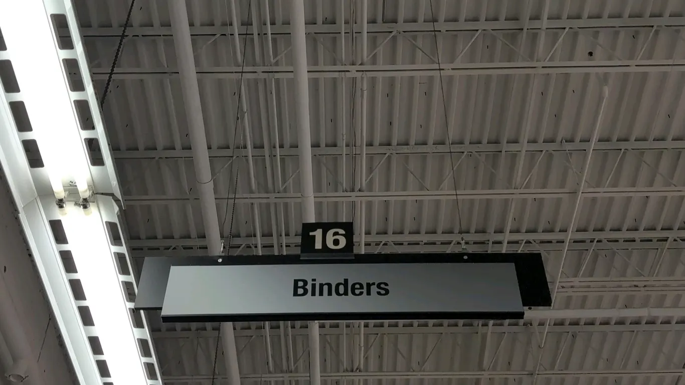 Quantity of hanging retail store aisle marker signs. Features category and department labels with numbered tabs including Binders, Briefcases, Educati