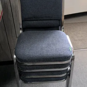 Upholstered stacking chairs. Features blue fabric cushioned seats and backrests with chrome metal frames.