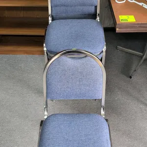Cloth cushioned stacking chairs. Features blue fabric upholstered padded seat and backrest. Chrome-finish metal frame with protective floor glides.