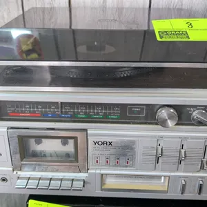 Yorx M 2674 AM/FM stereo cassette recorder and 8-track player. Features top-loading turntable with dust cover, front-loading cassette deck, 8-track ca