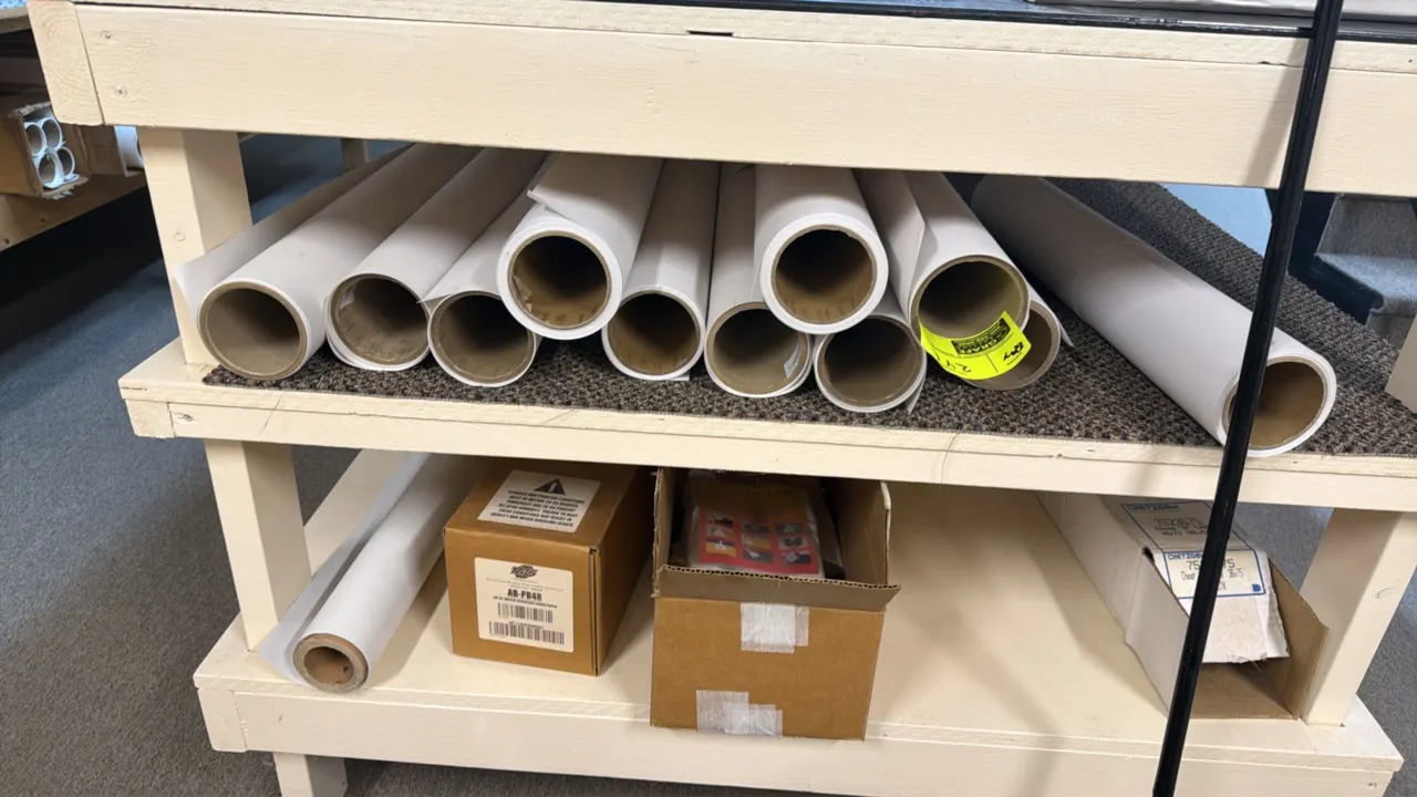 Assorted plotter paper rolls compatible with HP DesignJet Z6 Pro production printers. Includes loose rolls and boxed media. Shelving unit and surround